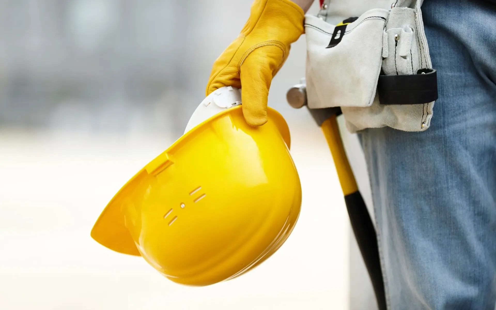 A photo of a worker holding a hard hat.